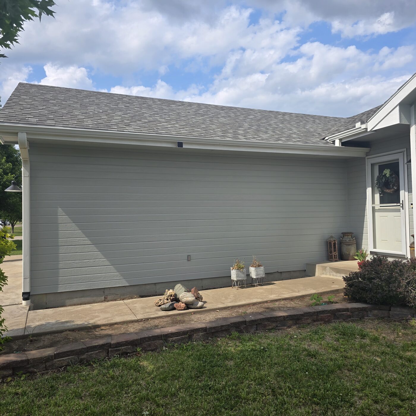 Full exterior repaint - sage green siding with white trim - Topeka KS
